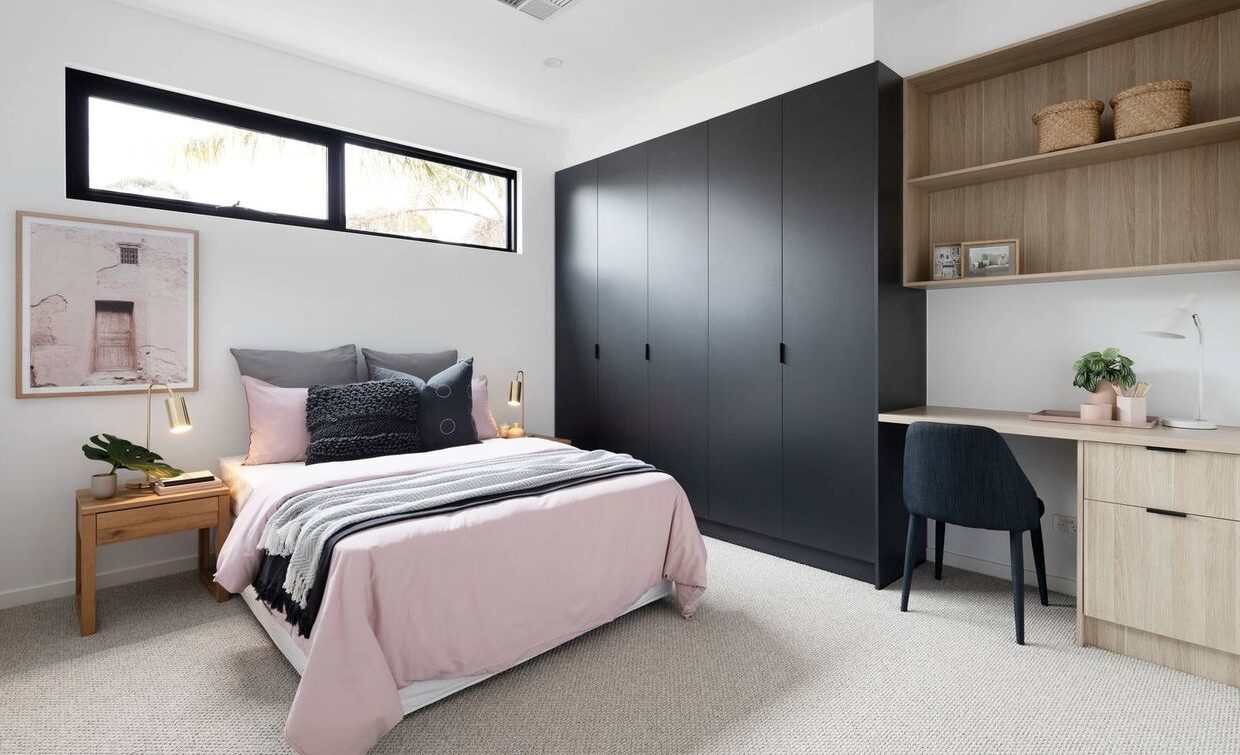 bedroom with long length cupboards and a small study nook