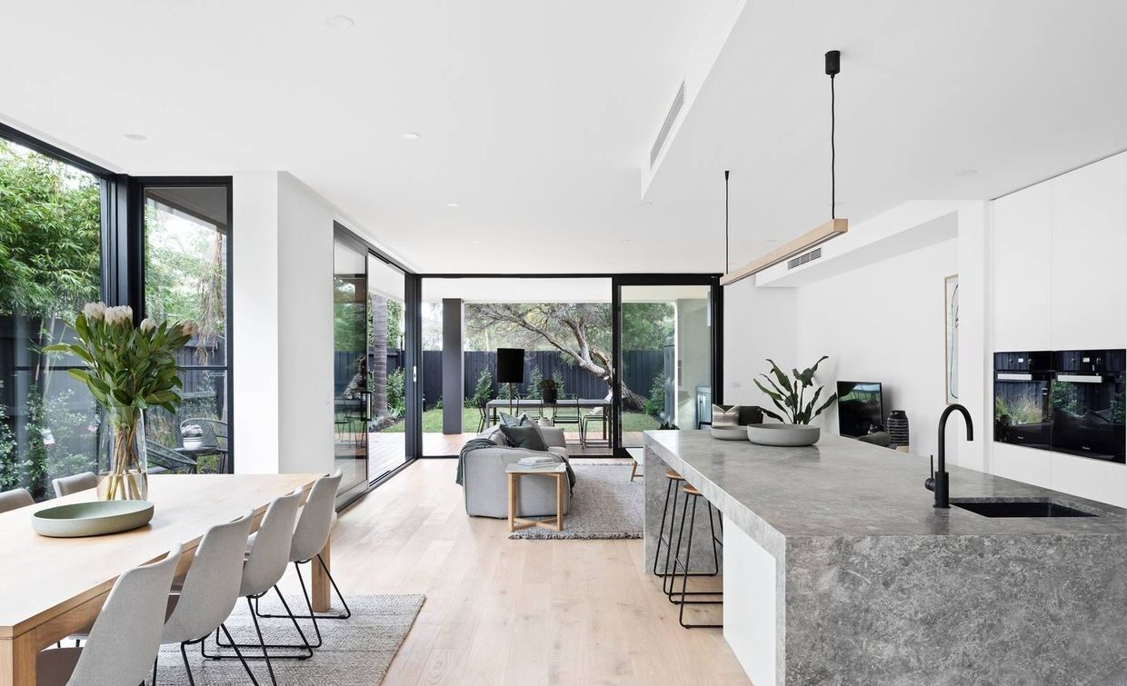 looking from the right hand side of kitchen over the dining area, kitchen, living room and out into the outdoor living area and backyard