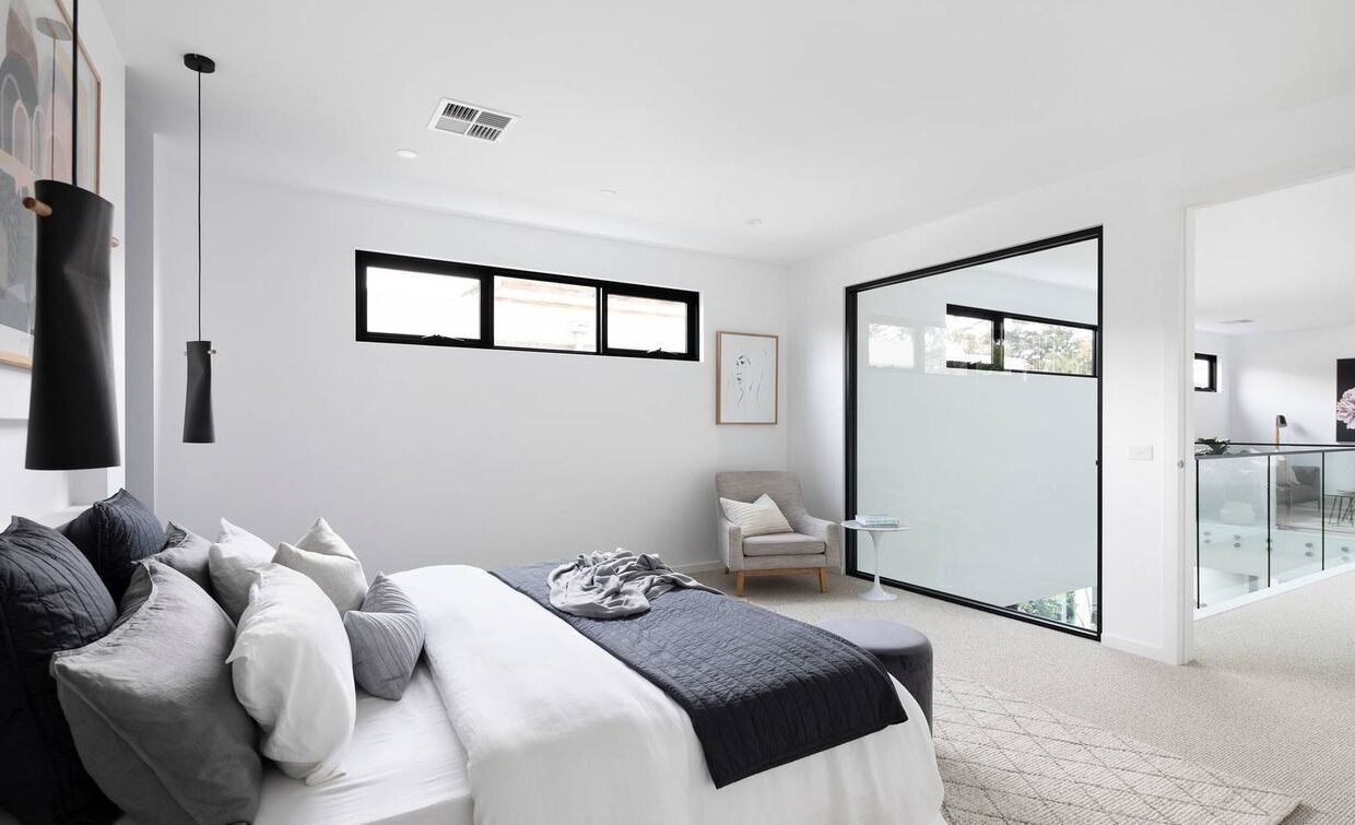 bedroom with dark coloured cylindrical lamps, window to look down over the 2nd lounge room