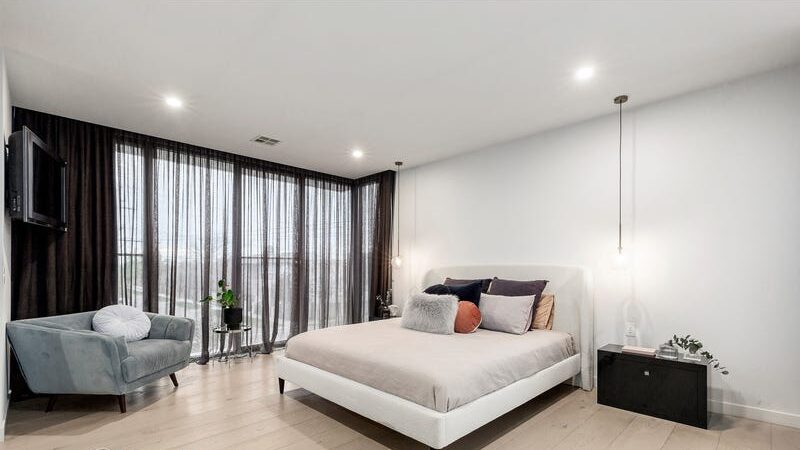 66 thomas st brighton east bedroom with sheer curtains, tv in the corner and a small lounge chair