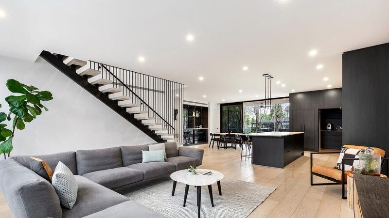 66 thomas st brighton east large lounge room and kitchen with black cupboards and island bench
