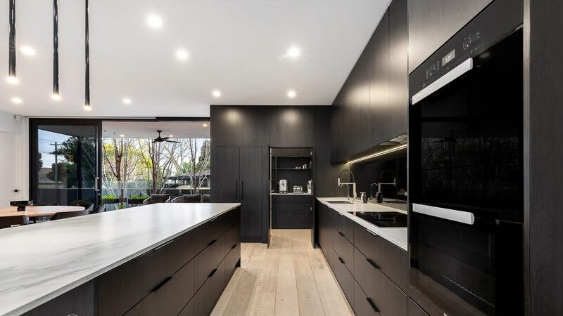 66 thomas st brighton east kitchen with floor to ceiling cupboards dark timber finish, black hanging lights