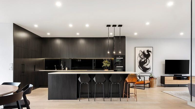 66 thomas st brighton east another look at the kitchen with dark timber cupboards and shelving, as well as the dark timber island bench with 4 stools underneath
